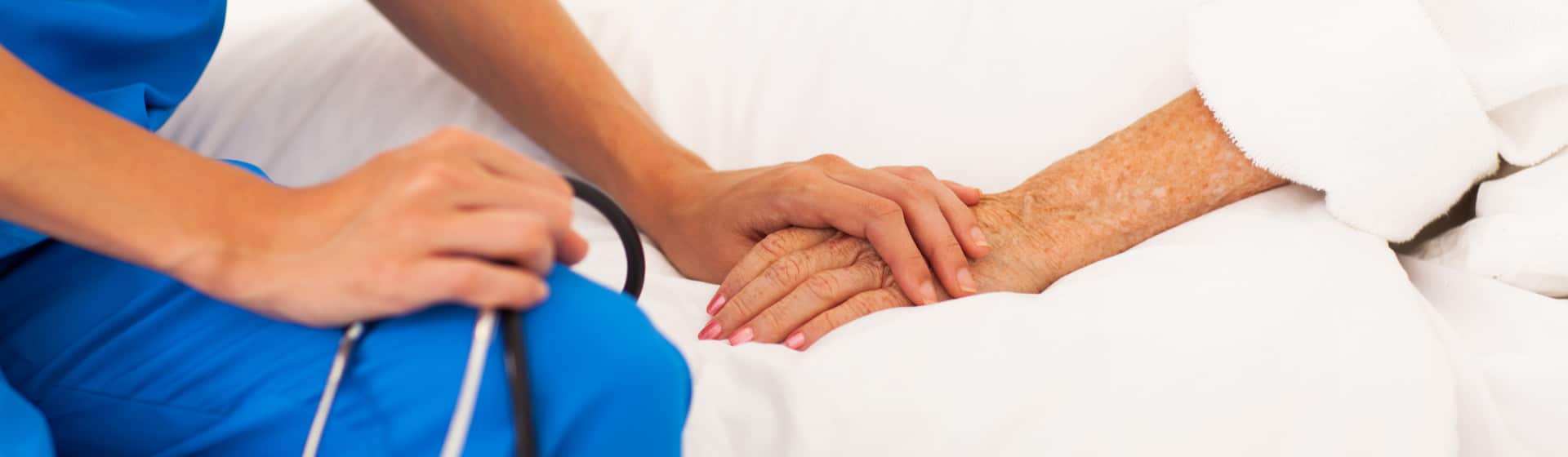 Close up of nurse holding an old ladies hand