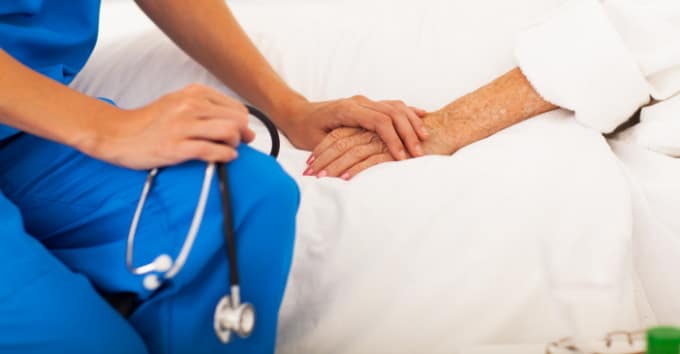 Nurse holding an old lady by the hand